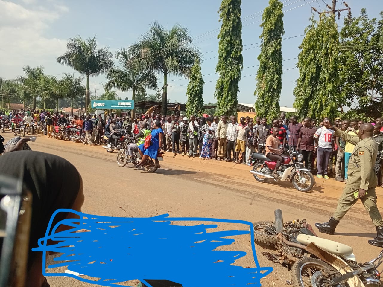 Abantu nga beetegereza omulambo ogubadde gulagamye ku kkubo.
