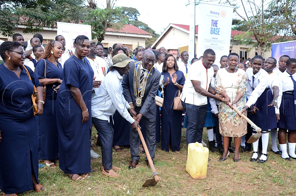 Rotarians led by Daniel Ddamulira (in suit with chain of office) the District 9214 Governor and Roger Sembeguya (white shirt front) the president of the Rotary Club of Entebbe Base join the students and staff of Entebbe Comprehensive Secondary School to break ground for the construction of a water borne toilet at the school in Entebbe municipality. This was on Tuesday. (Credit: Lawrence Mulondo)