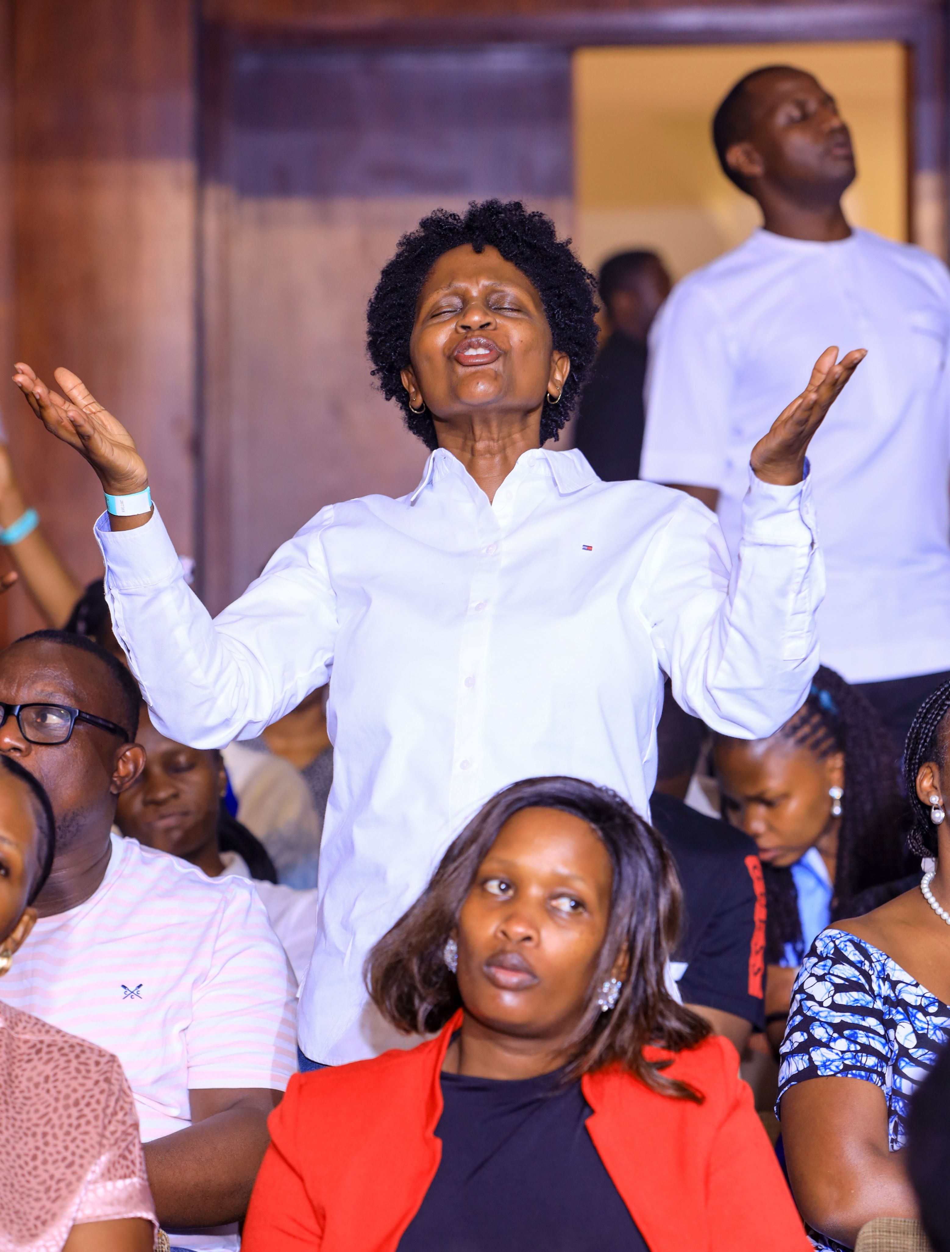 An attendee is engrossed in prayer during the concert. Photo by Alfred Byenkya