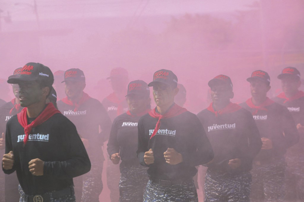 Young participants jog while being tear-gassed during a special operations course in Caracas, Venezuela, on September 9, 2025. (Photo by Ivan Mc Gregor / Anadolu via AFP)