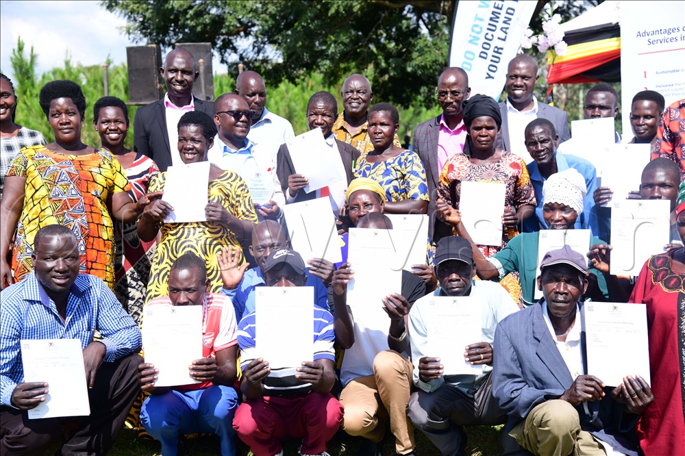 Beneficiaries and leaders pose with their land titles.