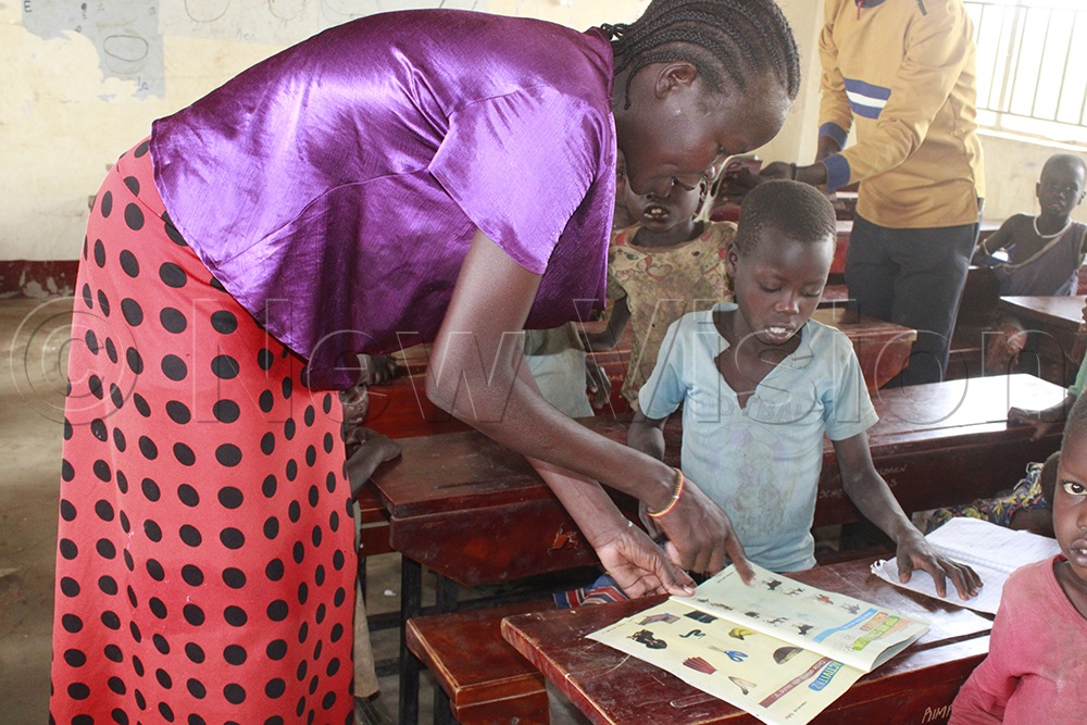 Lucy Peace Akong, a mentor, guides a learner through an animal-matching activity in Toto Magazine. (Credit: Ritah Mukasa)