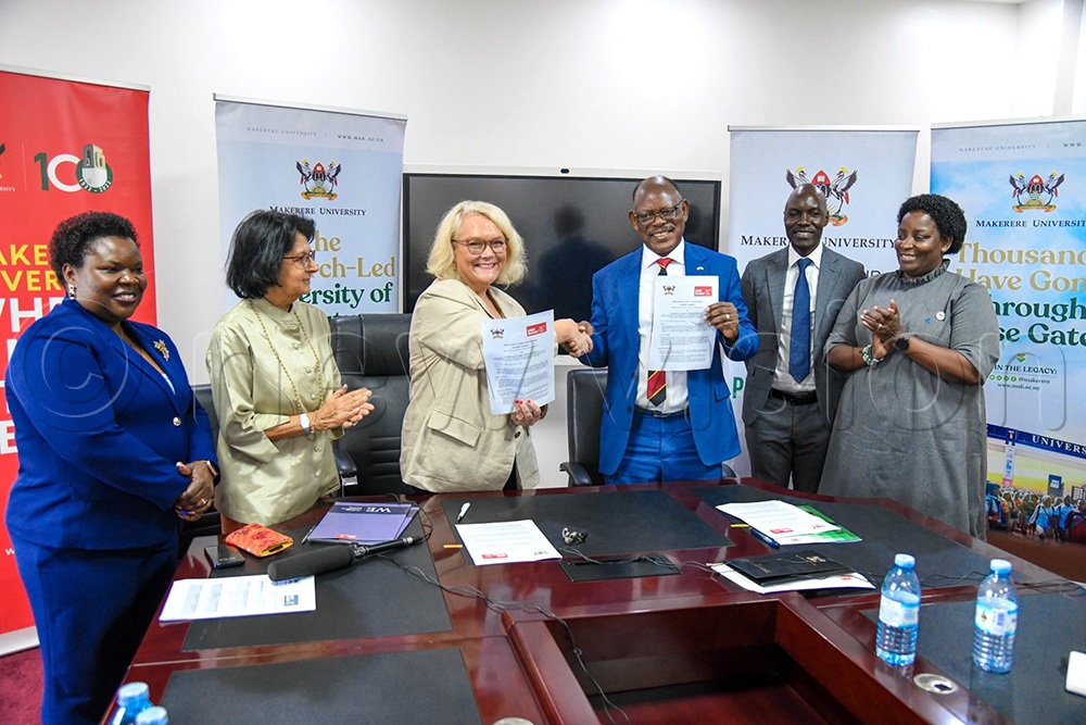 Nawangwe and University of the West England Vice-Chancellor exchange documents. Left is Miriam Otengo, the head of commercial and economic diplomacy at the Uganda High Commission in the UK.