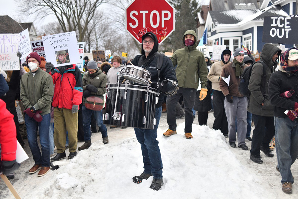 A protester holds drums as they march from Powderhorn Park in Minneapolis against Immigration and Customs Enforcement (ICE) and the fatal shooting of Renee Good by an ICE agent, calling on federal authorities to leave the city and demand accountability, in Minneapolis, Minnesota, on January 10, 2026. (Photo by Octavio JONES / AFP)