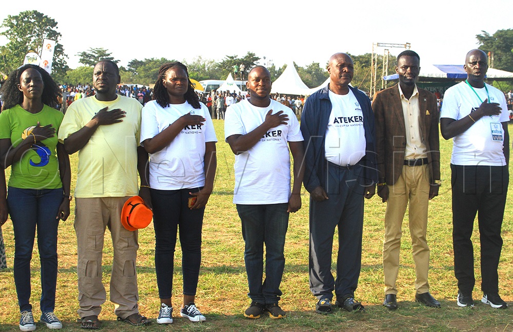 South Sudan’s Eastern Equatoria State Governor, H.E. Louis Lobong Lojore (centre, in black sports coat), sings the national anthems alongside members of the Ateker Sports and Arts Foundation (ASAF) organising committee at Oligoi Stadium on Wednesday. (Photo by Alfred Atwau)