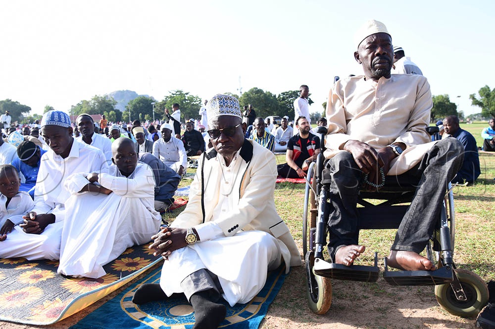 Soroti RDC Hajji Imuran Mulunga seated next to a Muslim man living with disabilities as they prayed during the Eid Al Adha prayers at Soroti sports ground. (Credit: Godfrey Ojore)