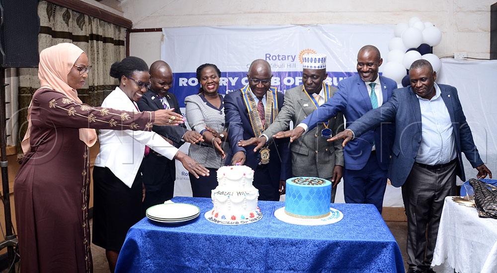 Daniel Mukasa Ddamulira (C), the Rotary District 9214 Governor, Hajji Musa Nyago (third from right), the charter president of the Rotary Club of Kibuli Hill and other Rotarians cut cake to celebrate the Rotary Club of Kibuli Hill charter. This was at Kibuli Secondary School on September 29, 2026. (Credit: Lawrence Mulondo)