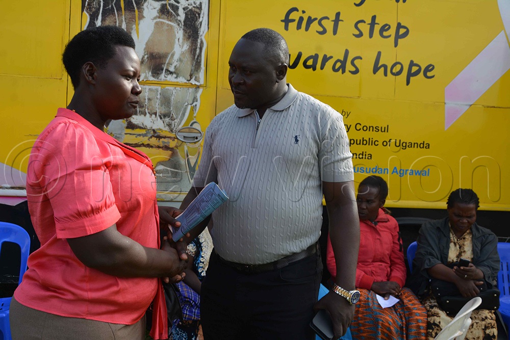 Buhaguzi East MP Steven Asera Rwaitaza sharing with one of the locals who turned up for the medical camp. (Photo by Peter Abaanabasazi)