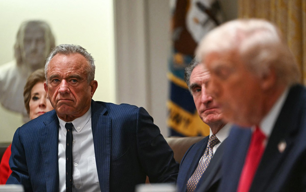 US Secretary of Health and Human Services Robert F. Kennedy Jr. (L) looks on as President Donald Trump speaks during a Cabinet Meeting in the Cabinet Room of the White House in Washington, DC on December 2, 2025. (Photo by ANDREW CABALLERO-REYNOLDS / AFP)