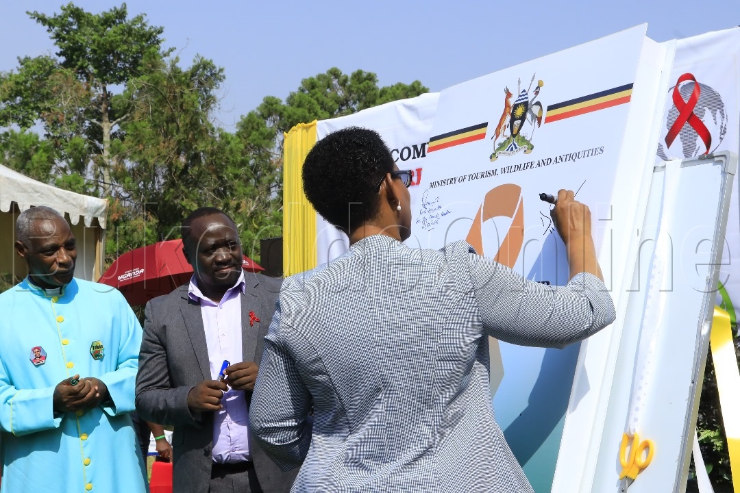 Omuwandiisi we Nkalakalira okuva mu Kitongole kye byobulambuzi nga ateekako omukono ku kiwandiiko