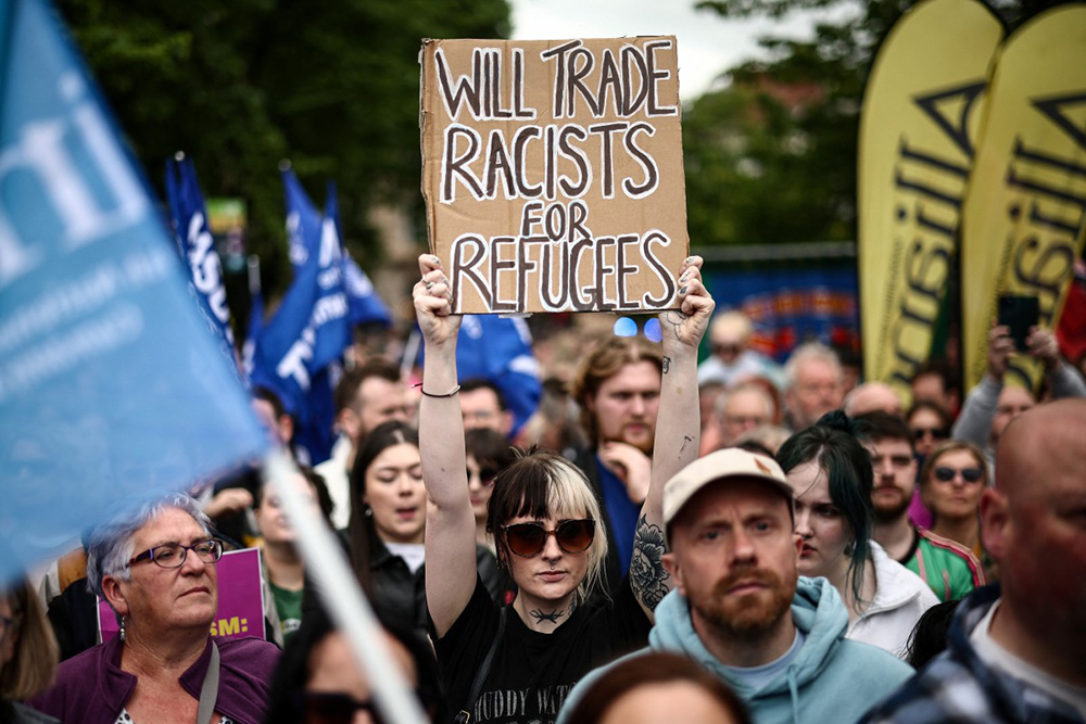 People turn out for a demonstration against racism and call for calm in central Belfast, Northern Ireland on June 13, 2026, after a few nights of disorder hit the city when video of a knife attack on June 8 went viral across social media platforms. (AFP)