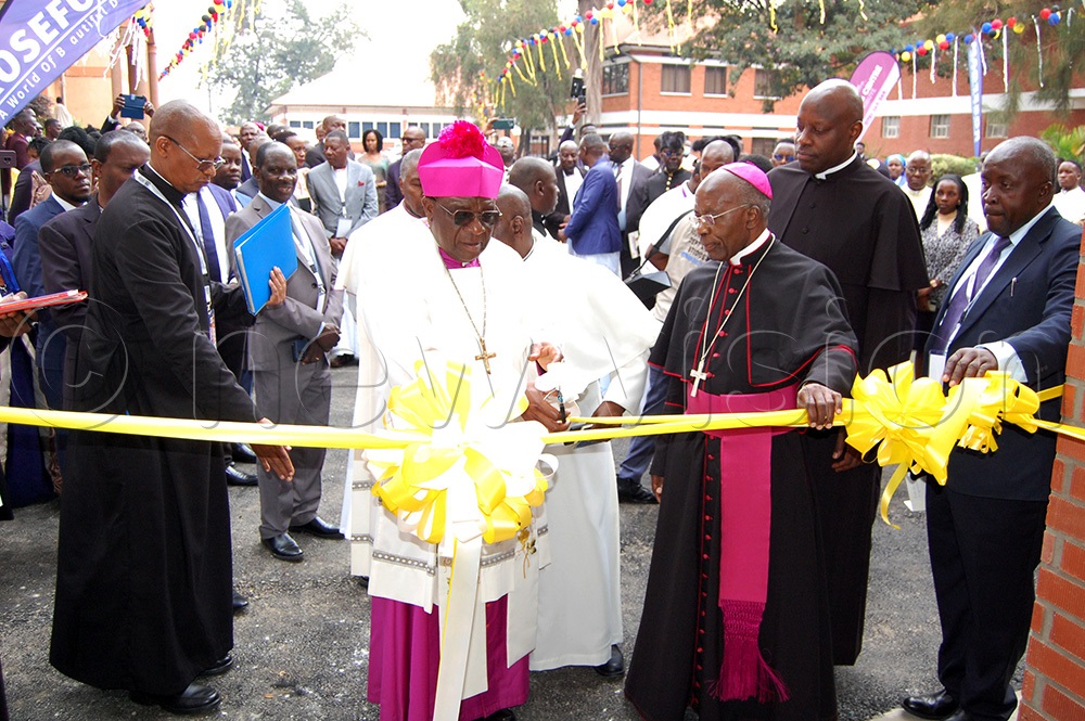 Archbishop Paul Ssemogerere (wearing a biretta) cuts a tape to commission the newly-redeveloped presbytery of Rubaga Cathedral parish on Sunday, October 25, 2025. (Photo by Mathias Mazinga)