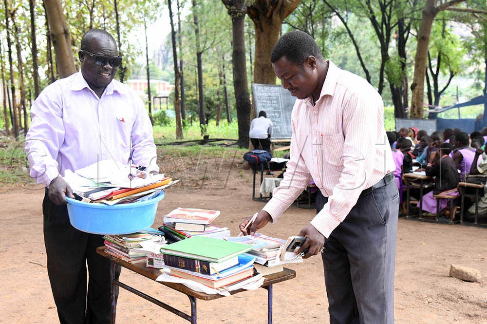 Teachers operating under a tree shade after their office got damaged when strong rains and wind deroofed their office. (Credit: Godfrey Ojore)
