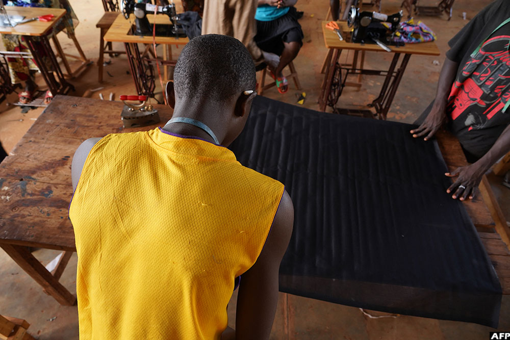  A student takes measurements on a piece of fabric during the sewing class 