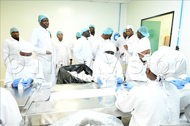 Dr. Mathias Magoola, second from the left (standing) leading a team to tour inside the factory.