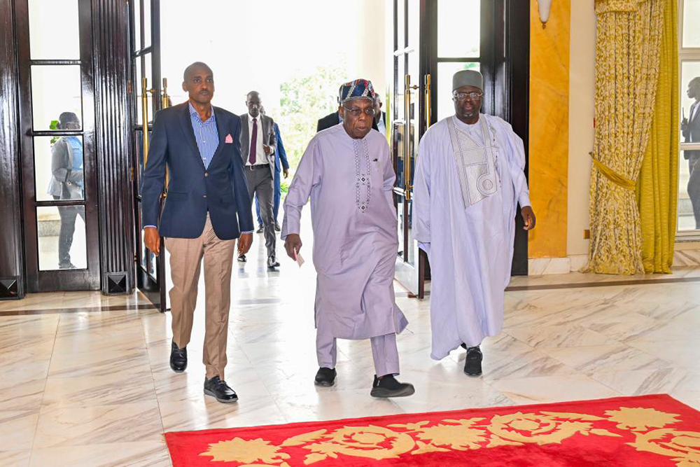 Tumwebaze with Olusegun Obasanjo after his arrival at the State House. (PPU)