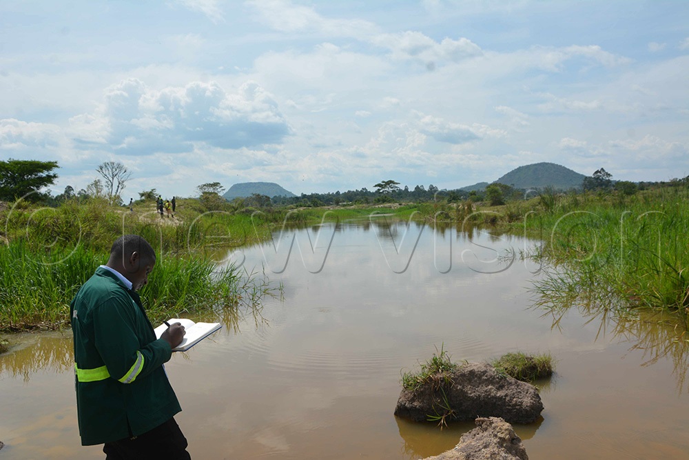 A NEMA official carrying out an assessment of the abandoned gold exploration site. (Photo by Peter Abaanabasazi)