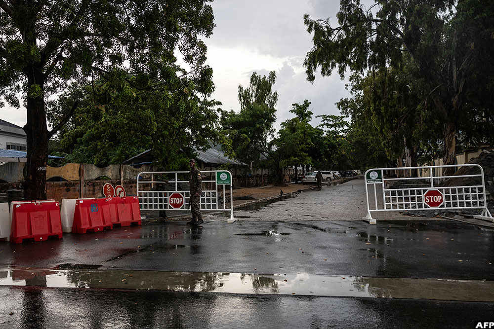 A soldier stands at the entrance of a blocked road next to the National Television, Benin TV, in Cotonou, on December 8, 2025