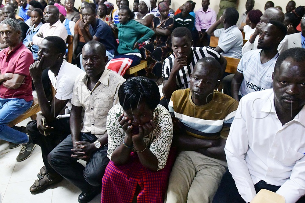 The mother of the slain twins holds her cheeks in grief as her husband, John Oluma (in a T-shirt), sits beside her during the court proceedings. (Credit: Godfrey Ojore)