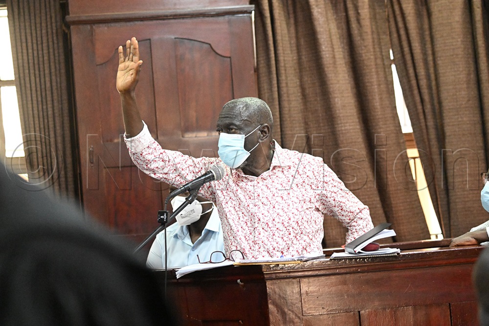 Besigye raising his hand in court. (Credit: Maria Wamalal)