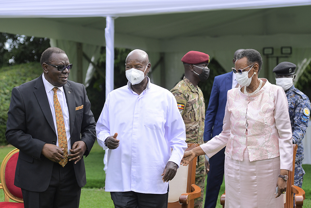 Hon. Chris Rwakasisi (left) sharing a light moment with President Museveni and the First Lady, Maama Janet Museveni, during the National Prayer Breakfast. (PPU)