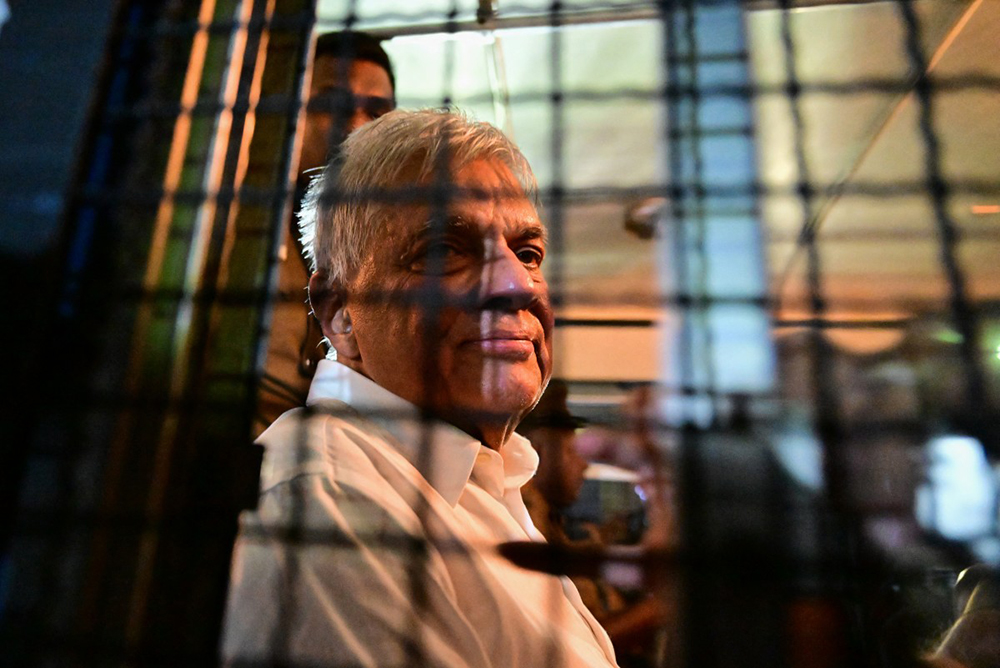 Sri Lanka's former president Ranil Wickremesinghe looks on as he sits in a prison bus in Colombo on August 22, 2025, after a magistrate ordered him to be held in remand custody till August 26, 2025, following allegations that he misused state funds to travel to Britain in 2023. (Photo by Ishara S. KODIKARA / AFP)