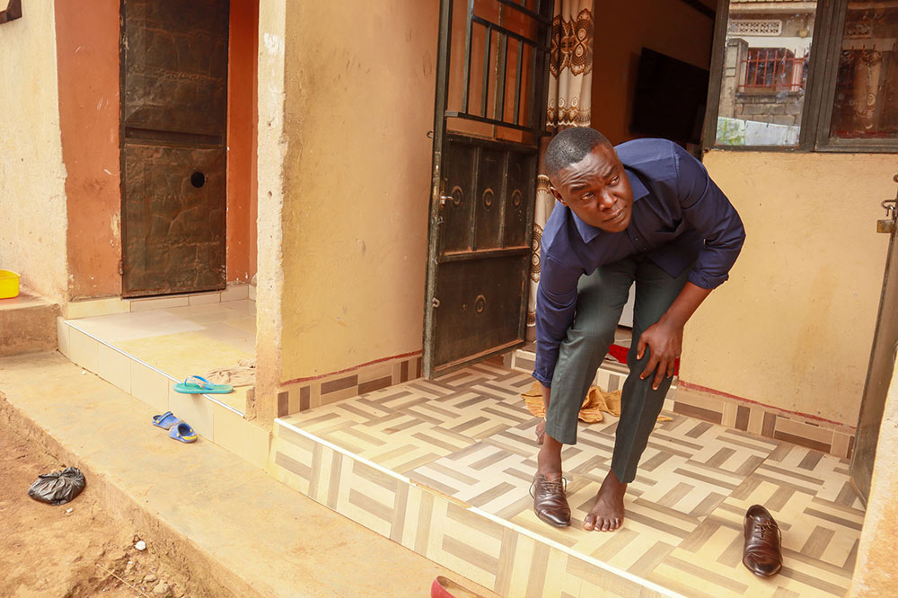 Benjamin Akiso puts on his shoes outside his hostel near Kyambogo University. Arrested during a student meeting in April, Akiso says his expulsion is part of a wider effort to silence university students. (Photo credit: Nakisanze Segawa, GPJ Uganda)