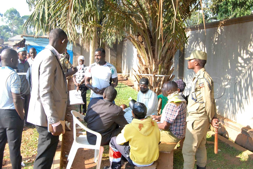 Residents of Panda PL Zone in Luzira check their names in the register ahead of participating in the LC1 elections. (Photo by Huzaima Kaweesa)