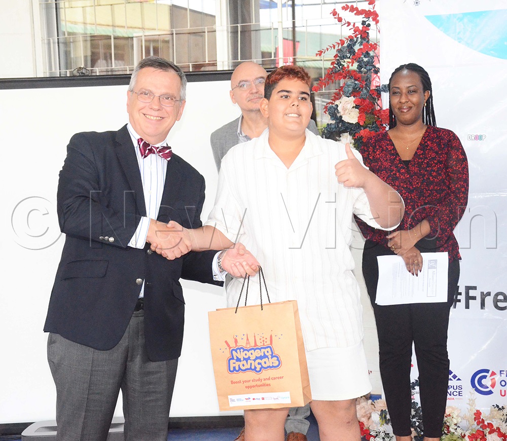 The Belgian Ambassador to Uganda, Hugues Chantry giving certificate to Shah Jinal of Aga Khan Primary School during the awarding ceremony. (Photo by Isaac Nuwagaba)