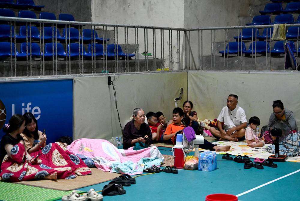 People take shelter inside the Nghe An Provincial Gymnasium in Vinh city, Nghe An province on August 25, 2025, before Typhoon Kajiki makes landfall in Vietnam.