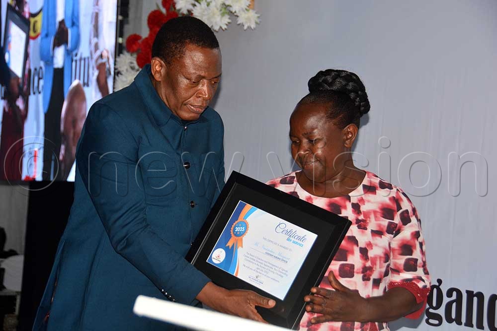 The director general of health services Dr Charles Olaro, hands a certificate to Margaret Nassimbwa assistant nursing officer for outstanding contribution to the science of nursing oncology during the Uganda Cancer Institute end-of-year party at Protea Hotel in Kampala on November 28, 2025. (Credit: Francis Emorut)