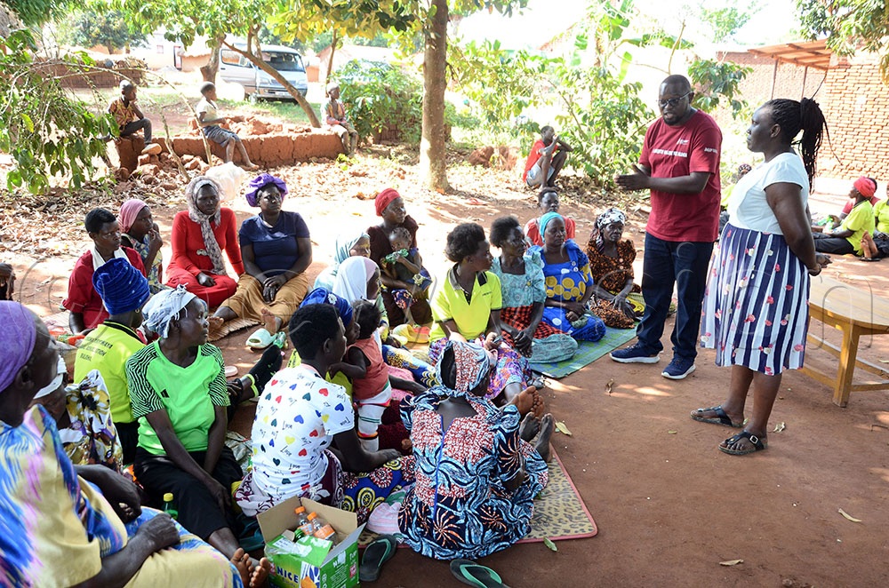   Sumaya Birungi, a midwife at Muterera Health Centre III in Bugiri district and Moses Iyereget, the Social Sustainability Fund Project Officer at Amref Health Africa Uganda, address members of Byobona Women Farmers Group during a session on access to sexual reproductive health services. This was in Nakyegereike village, Buliida A parish, Bugiri district. (Credit: Lawrence Mulondo)