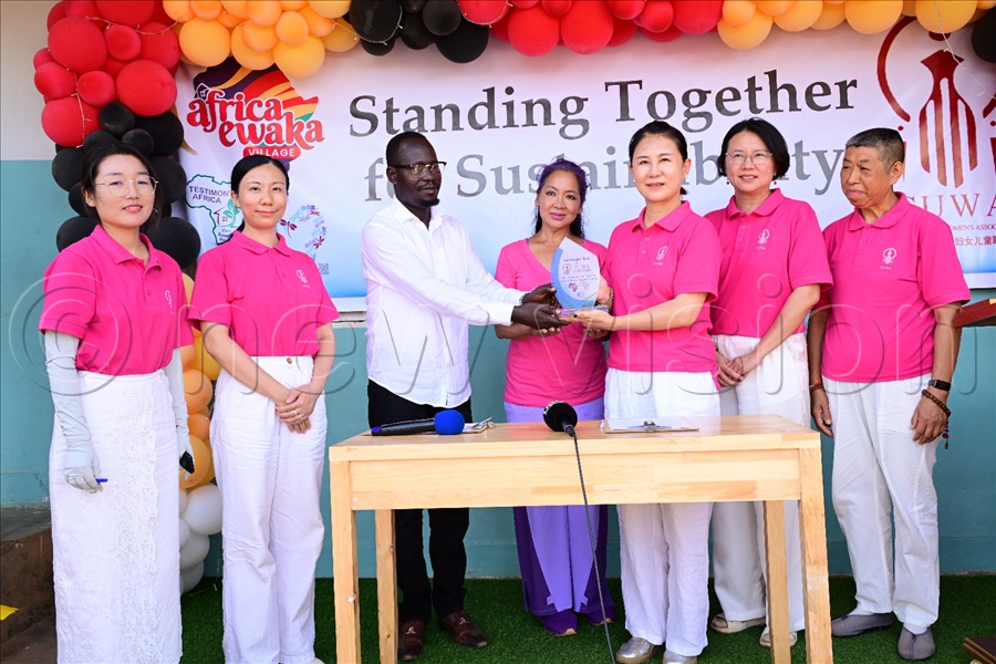 Gilbert Olinga of the Africa Ewaka project and CUWA president Tong Fang exchange documents after signing an MOU. (All Photos by Eddie Ssejjoba)