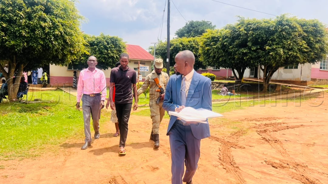 Ssentebe Mugisha (akulembedde mu ssuuti) ng'ali n'abaserikale abaakutte omumyuka wa heedimaasita (mu biddugavu)