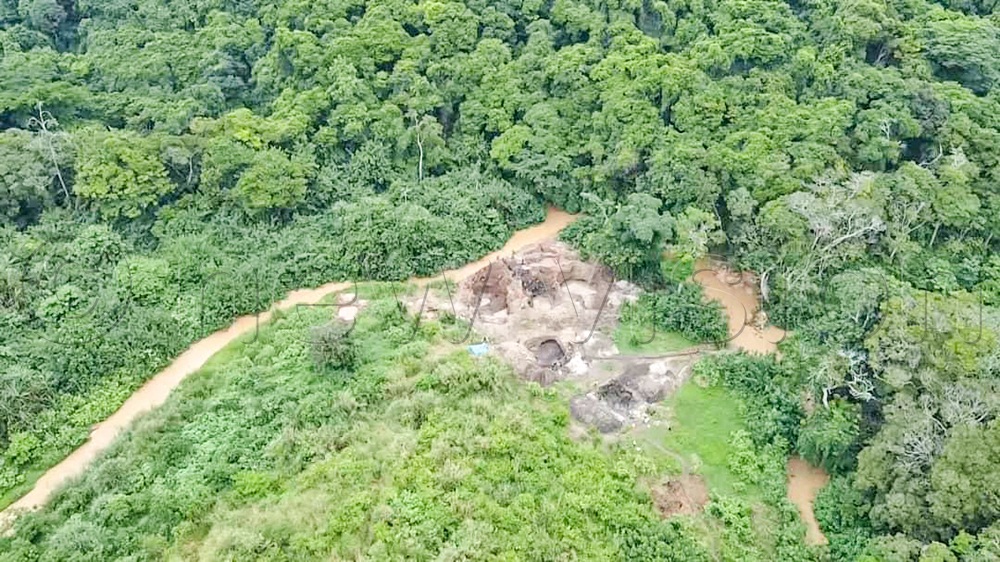 An aerial view of small mining pits (middle ground) next to Kasyoha-Kitomi Forest Reserve and the polluted River Buhindagi separating the forest and private land in Kyabakara sub-county, Rubirizi district. (Credit: Gerald Tenywa)