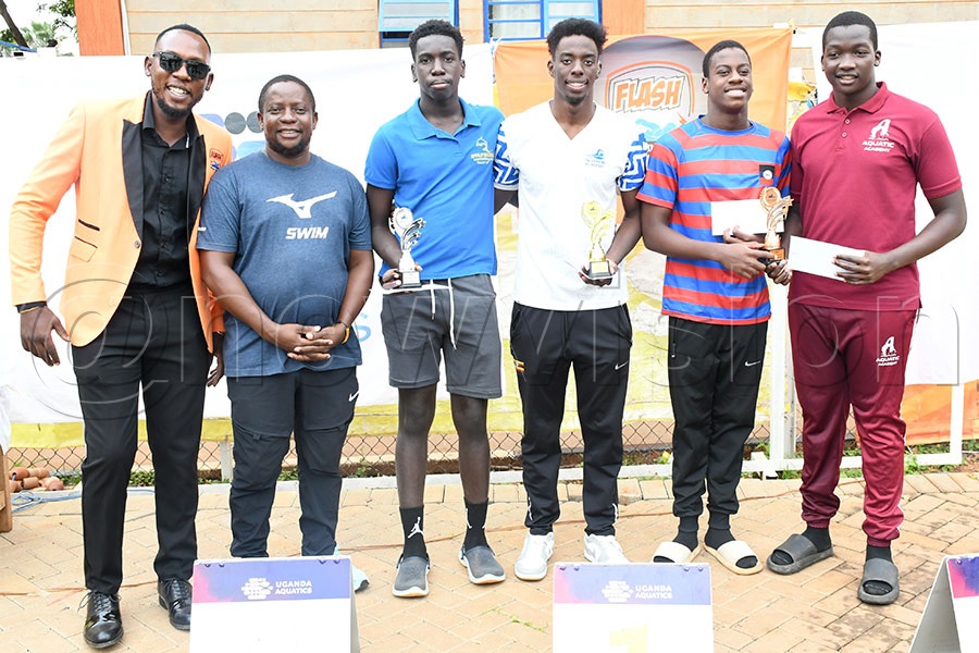 The top swimmers in the 15&over category Larry Graig Feni (3rd right), Shadrack Mwebaze (3rd left), Blessed Elijah Wamala and Joshua Dragu Mandre (right) pose with Flash Chairman Peter Buvumbo and Uganda Aquatics' vice president Tonnie Kasujja (2nd left). Photo by Michael Nsubuga
