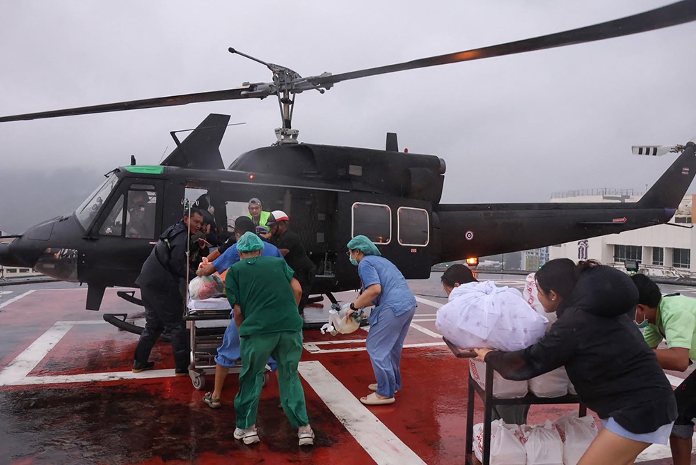 MMedical workers transporting a patient to be evacuated on an army helicopter on the roof of a hospital impacted by floods in Hat Yai. 