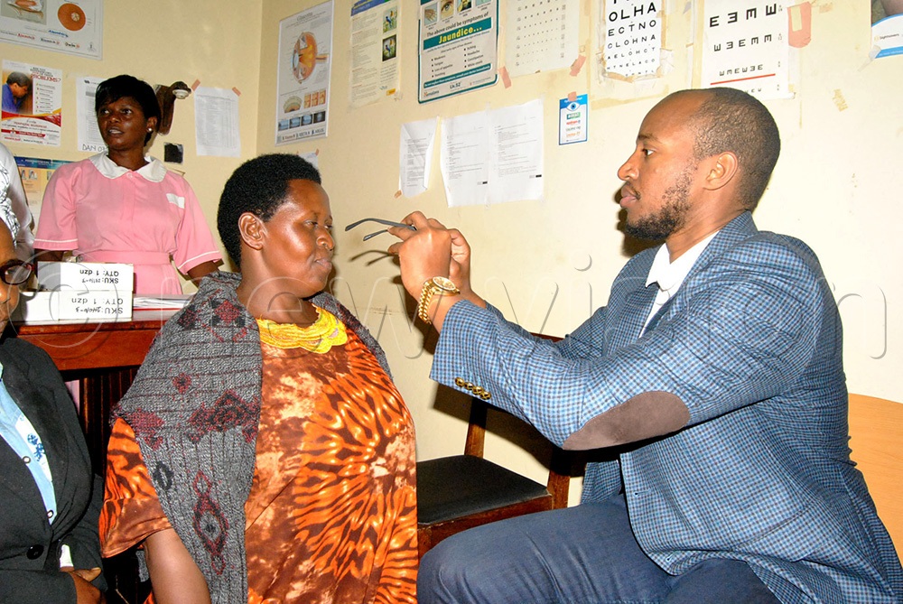 Mary Baguma, an eye patient recieves reading glasses from King Oyo at the Fort Portal regional Referral Hospital Buhinga ahead of Empango celebrations. (Photo by Sunday Rogers)