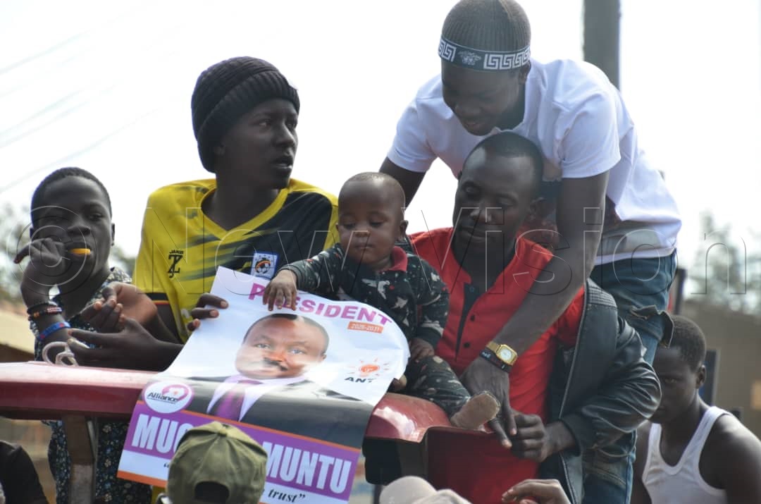 A young child touching Muntu's campaign poster. (Credit: Stuart Yiga)