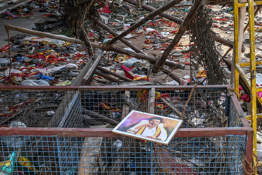 A portrait of actor-turned-politician Vijay is seen near the scattered shoes after a stampede that broke out last evening during his political rally in the Karur district, in the Indian state of Tamil Nadu, on September 28, 2025. A stampede that killed dozens at a south India political rally happened after a crowd of thousands waited hours in baking heat without sufficient safeguards, officials and witnesses said on September 28.