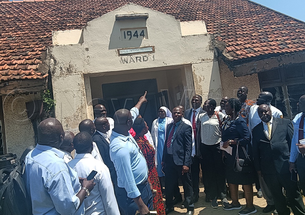 Soroti City East MP Moses Attan showing commitee members one of the buildings during inspection. (Credit: Felix Osujo)