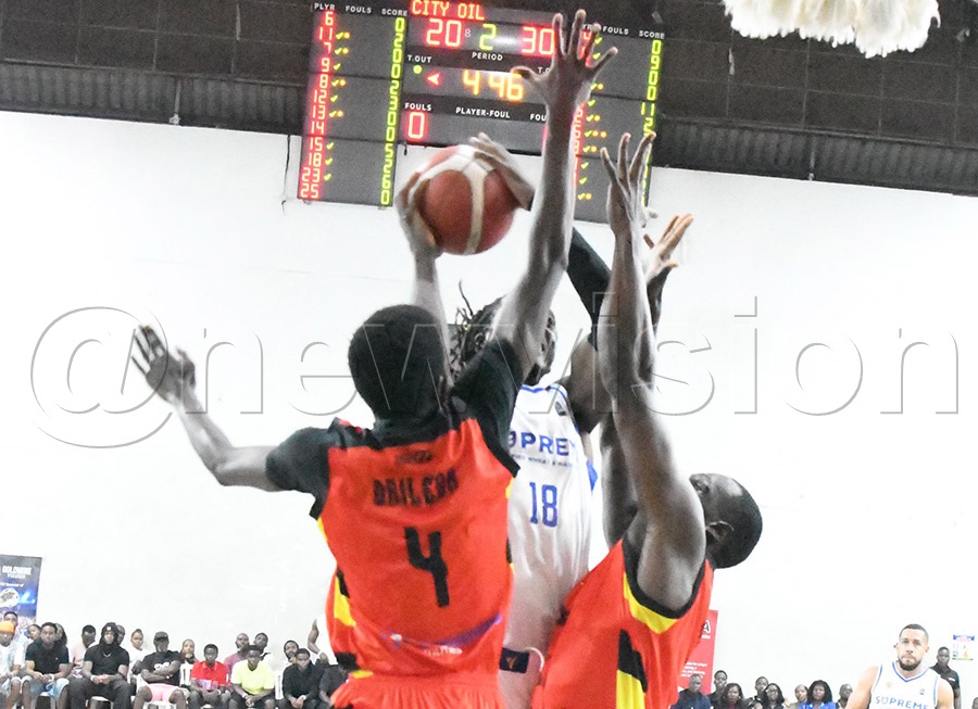 Oilers' Jonathan Komagum (center) is blocked by Nam Blazers' Tony Drilleba (left) and Nyemeck Kevin Leonel during the FUBA finals at Lugogo. Photo by Michael Nsubuga