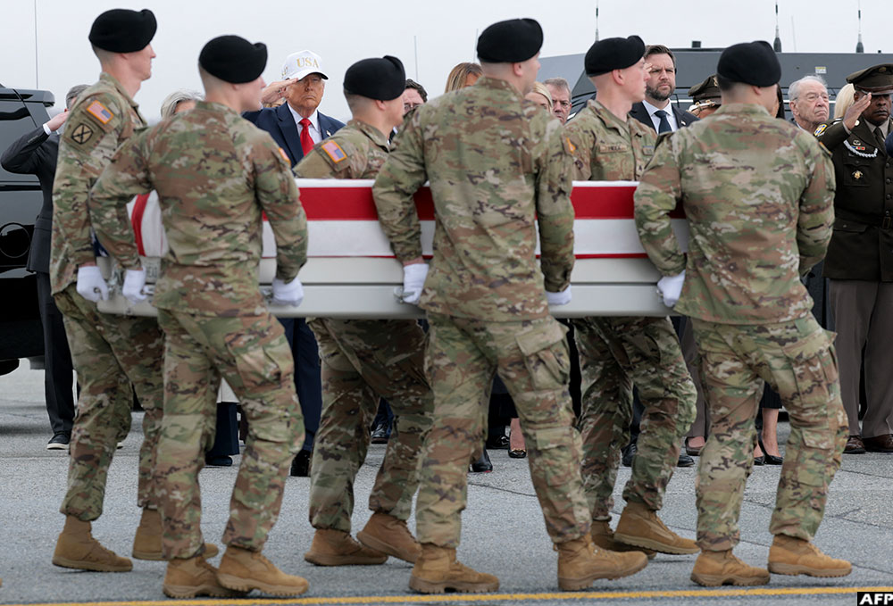 US President Donald Trump and Vice President JD Vance salute as a US Army carry team moves a flag-draped transfer case during a dignified transfer at Dover Air Force Base on March 7, 2026 in Dover, Delaware