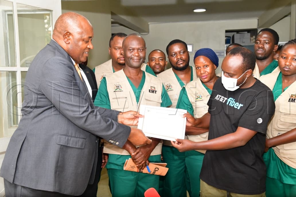 Health Minister Dr Chris Baryomunsi presents a certificate to the last Ebola survivor at the Mulago Isolation Unit. (Credit: Mpalanyi Ssentongo)