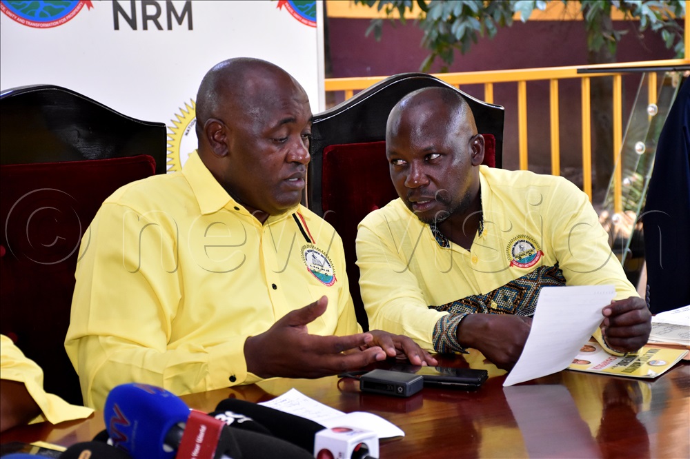 Chris Baryomunsi, the  NRM Vice Chairperson Western sharing a light moment with Godfrey Kiwanda, the NRM vice chairperson of the NRM party in Buganda region at the NRM secretariat during a press briefing  