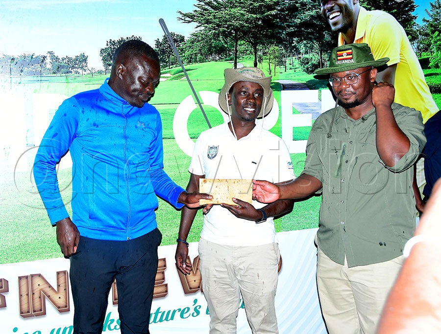 Kilembe Golf Club chairman Ronald Kwikiriza (right) and Hima Cement's Phillimon Mubiru present a cash prize of sh1.7m to Joseph Cwinyaai, winner of the inaugural Kilembe Open. Photo by Silvano Kibuuka