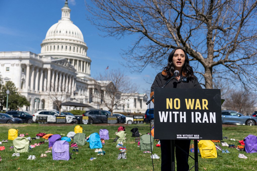 U.S. Rep. Yassamin Ansari (D-AZ), who is leading the impeachment effort, speaks on Capitol Grounds in front of a memorial of 168 pairs of shoes representing those killed in the U.S. strike on an Iranian school, on March 18, 2026 in Washington, DC. (Tasos Katopodis/Getty Images for Win Without War/AFP)