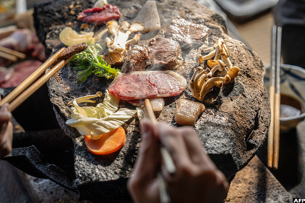 People cooking bear meat and vegetables at a restaurant in Chichibu, Saitama prefecture