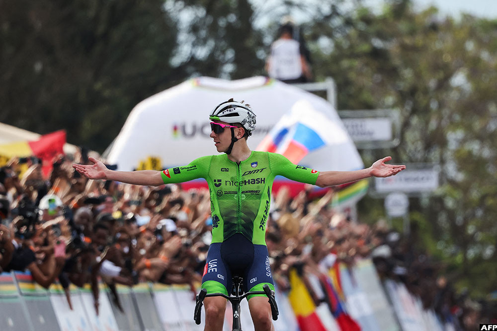 Slovenian rider Tadej Pogacar celebrates as he crosses the finish line to win the men's Elite road race cycling event in Kigali