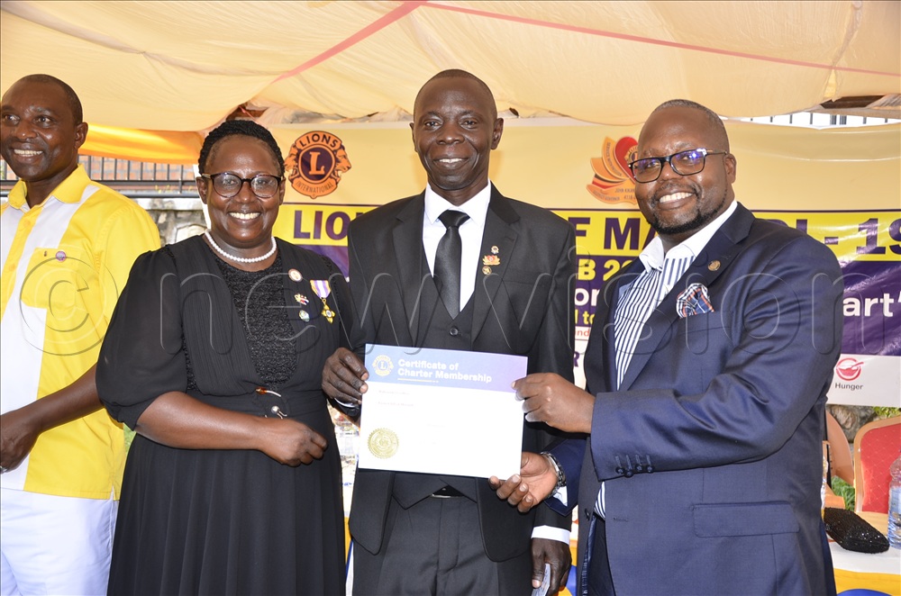 Godfrey Bahemuka (centre), the President of the Masindi Lions Club, receiving a certificate of charter membership from Rogers Byamukama (right), the MP for Masindi Municipality and Tush Natulinda, the District governor